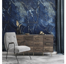 Fototapete mit blauem Marmormuster in einem Wohnzimmer mit Holzkommode und grauem Sessel.