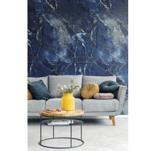 Vliestapete mit dunkelblauem Marmormuster und hellen Adern in einem modern eingerichteten Wohnzimmer mit grauem Sofa und Holztisch.