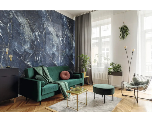 Modernes Wohnzimmer mit dunkelblauer Marmor-Tapete, grünem Samtsofa und Fischgrätenparkett. Dekoriert mit Zimmerpflanzen und Goldakzenten.