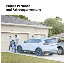 Überwachungskamera an einer Hauswand mit präziser Personen- und Fahrzeugerkennung einer Familie und eines Autos vor einer Garage.