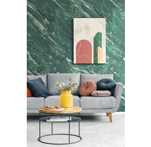 Modernes Wohnzimmer mit Tapete in grüner Marmoroptik, grauem Sofa mit dekorativen Kissen und einem runden Couchtisch vor abstrakter Wandkunst.