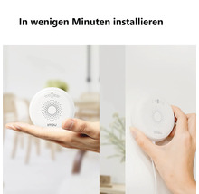 Ein runder weißer Imou Sensor wird in der Hand gehalten und zur Installation an einer Wand befestigt.