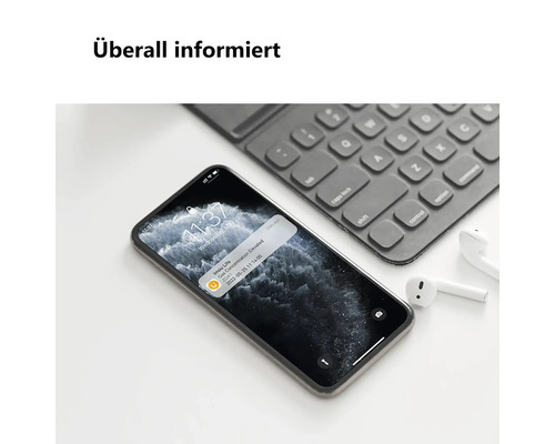 Überall informiert. Smartphone zeigt eine Gasalarm-Benachrichtigung der Imou Life App auf einem Schreibtisch neben einer Tastatur.