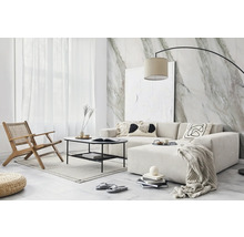 Modernes Wohnzimmer mit heller Eckcouch, schwarzem Metalltisch und Sessel. Die Wand ist mit einer Fototapete in Marmor-Optik gestaltet.