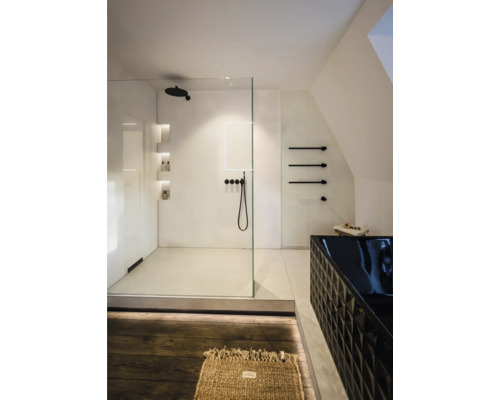 Modernes helles Badezimmer mit begehbarer Glasdusche, schwarzen Armaturen und einer strukturierten schwarzen Badewanne. Minimalistisches Design.