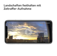 Smartphone zeigt eine Zeitraffer-Aufnahme eines Sonnenuntergangs über einer Stadt.