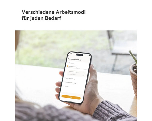 Person hält Smartphone mit App zur Auswahl verschiedener Arbeitsmodi wie Standard oder Hochleistung.