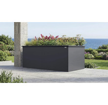 Großes, anthrazitfarbenes Weka Metall-Hochbeet auf einer Terrasse mit Meerblick, bepflanzt mit Gräsern und verschiedenen Pflanzen.