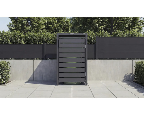 Mülltonnenbox aus Metall in Anthrazit mit horizontalen Lamellen auf einer gefliesten Terrasse vor einem Sichtschutzzaun.