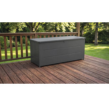 Dunkelgraue Gartenbox aus Metall auf einer Holzterrasse mit Geländer vor einem Garten.