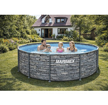 Familie in einem runden Marimex Aufstellpool mit Steinoptik in einem hellen Garten mit Haus im Hintergrund.