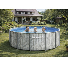 Rundes Marimex Aufstellbecken mit Rahmen in Holzoptik in einem hellen, weitläufigen Garten. Eine Familie schwimmt im Pool. Haus im Hintergrund.
