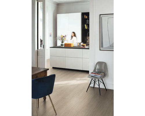 Moderner heller Raum mit Laminatboden in heller Holzoptik, einer weißen Kücheninsel mit dunkler Arbeitsplatte und Designerstühlen.