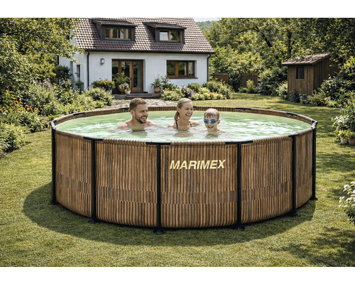 Runder Marimex Rahmenpool mit Verkleidung in Holzoptik in einem Garten mit einer Familie im Wasser vor einem Wohnhaus.