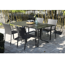 Gartenset bestehend aus einem rechteckigen Tisch und vier Flechtstühlen auf einer gepflasterten Terrasse vor Bambuspflanzen.