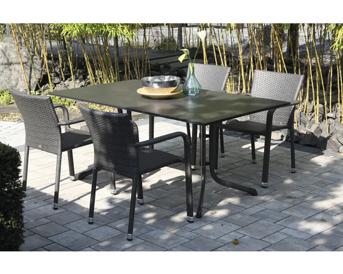 Gartenset bestehend aus einem rechteckigen Tisch und vier Flechtstühlen auf einer gepflasterten Terrasse vor Bambuspflanzen.