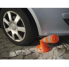 Flexibler orangefarbener Absperrpfosten aus Kunststoff mit Reflexstreifen, unter einem Auto zur Demonstration der Biegsamkeit.
