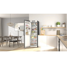 Moderne, helle Küche und Essbereich mit einem offenen, organisierten Kühlschrank voller Lebensmittel, Holzmöbeln und weißen Küchenschränken.