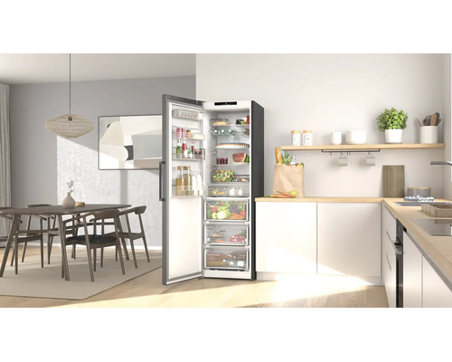 Moderne, helle Küche und Essbereich mit einem offenen, organisierten Kühlschrank voller Lebensmittel, Holzmöbeln und weißen Küchenschränken.