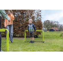 Kinder spielen mit einem kleinen tragbaren Fußballtor auf einer Rasenfläche im Garten.