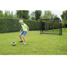 Ein Kind spielt Fußball auf einer Rasenfläche vor einem Fußballtor von EXIT Toys im Garten.