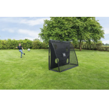 Mädchen spielt Fußball mit einem schwarzen EXIT Toys Rebounder mit Zielwand auf einer grünen Wiese im Garten.