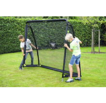 Zwei Jungen spielen im Garten mit einer EXIT Toys Rückprallwand auf einer Rasenfläche vor einer Hecke.