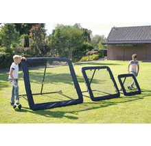Drei schwarze Fußball-Rebounder in verschiedenen Größen für das Training im Garten, zwei spielende Kinder auf einer Rasenfläche.