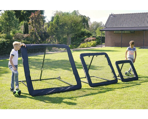 Drei schwarze Fußball-Rebounder in verschiedenen Größen für das Training im Garten, zwei spielende Kinder auf einer Rasenfläche.