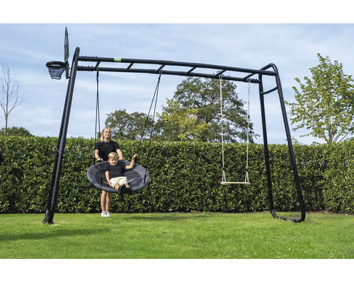 Schwarzes Klettergerüst aus Metall mit Nestschaukel, Holzschaukel, Basketballkorb und Hangelleiter in einem Garten.
