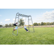 Klettergerüst aus Metall mit Schaukel, Kletternetz und Turnringen im Garten mit spielenden Kindern.