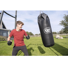 Ein junger Mann mit Boxhandschuhen im Garten neben einem schwarzen EXIT TOYS Boxsack, der an einem Metallrahmen auf einem hellen Rasen hängt.