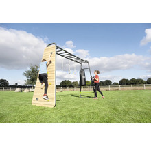 Großes Outdoor-Fitness- und Klettergerüst mit Kletterwand aus Holz, Hangelstangen, Turnringen und Boxsack auf einer Rasenfläche.