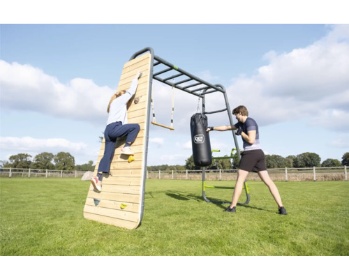 EXIT Toys GetSet Outdoor Fitnessstation aus Metall und Holz mit Kletterwand, Boxsack und Sprossenwand auf einer Wiese.