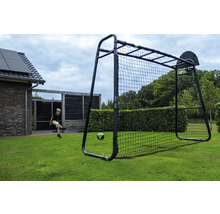 Ein Kind spielt Fußball in einem Garten mit einem großen schwarzen Fußballtor inklusive Basketballkorb auf einer Rasenfläche.