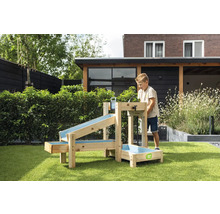 Ein Kind spielt mit einem hölzernen Wasserspielset von EXIT Toys im Garten. Das Set besteht aus mehreren Rinnen und einem Becken. EXIT Toys Logo.
