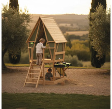 Abenteuer-Spielhaus aus Holz für Kinder mit Leiter, Sandkasten und Spielküche in einem hellen, weitläufigen Garten.