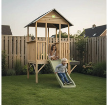 Spielhaus aus Holz mit Rutsche im Garten, EXIT Toys Logo, zwei spielende Kinder auf Rasenfläche vor Holzzaun.
