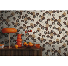 Vliestapete mit Blattmuster in Braun und Beige hinter einem Sideboard mit orangefarbener Lampe und Vase im Retro-Stil.