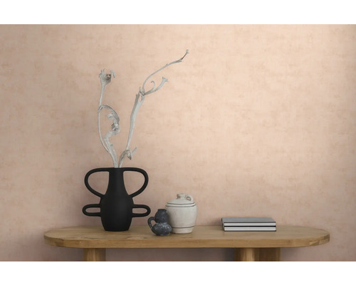 Strukturierte Vliestapete an einer Wand in einem modern eingerichteten Raum mit einem Holztisch, einer Vase mit Zweig, Keramik und Büchern.