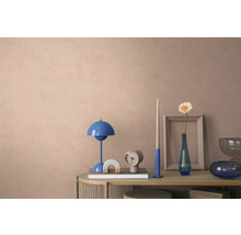 Dekorierte Konsole vor einer strukturierten Wand mit blauer Tischleuchte, Uhr und Vase mit Blume in einem modernen, organisierten Wohnraum.