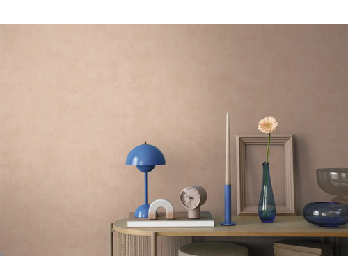 Dekorierte Konsole vor einer strukturierten Wand mit blauer Tischleuchte, Uhr und Vase mit Blume in einem modernen, organisierten Wohnraum.