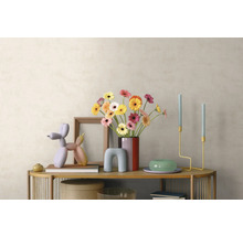 Moderne Inneneinrichtung mit Holz-Sideboard, buntem Gerbera-Strauß, Ballonhund-Skulptur, Kerzenständern und Bilderrahmen vor heller Wand.