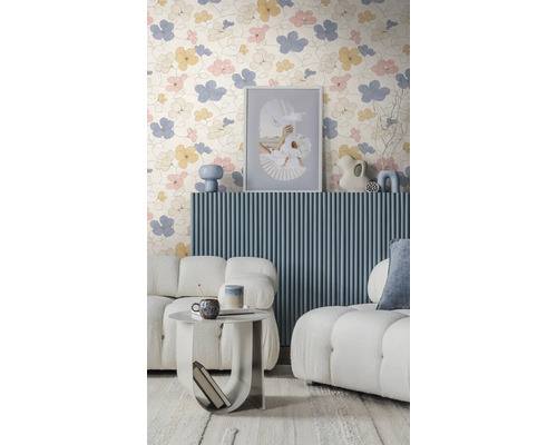 Modernes Wohnzimmer mit geblümter Tapete, blauer Wandverkleidung in Lamellenoptik, weißen Bouclé-Sofas und einem runden Beistelltisch.