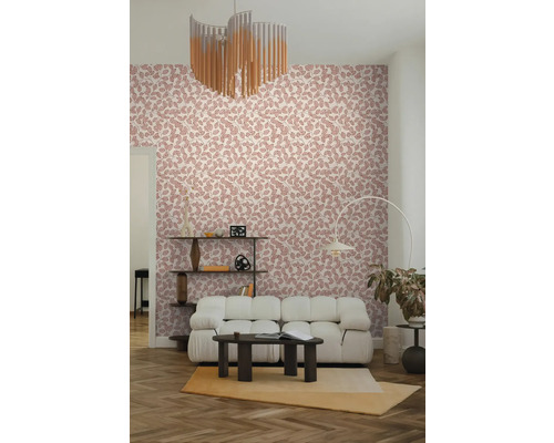 Vliestapete mit rosa Blattmuster in einem modern eingerichteten Wohnzimmer mit weißem Sofa und dunklem Couchtisch.
