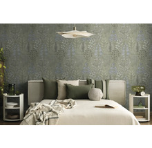 Helles Schlafzimmer mit botanischer Mustertapete, Bett mit Stoffkopfteil, grünen und beigen Kissen sowie weißen runden Nachttischen.