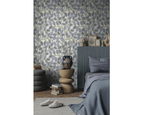 Modernes Schlafzimmer mit Tapete mit Blattmuster. Bett mit grauer Bettwäsche, geripptes Wandelement und ein Holztisch mit Vase.