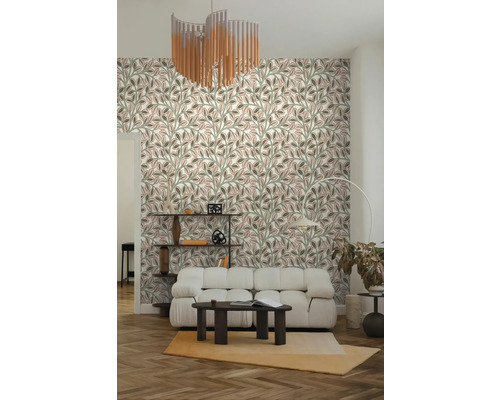 Wohnzimmer mit Tapete im Blattmuster, weißem Polstersofa, dunklem Couchtisch, Fischgrätparkett und modernem Kronleuchter.