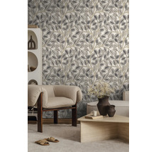 Modernes Wohnzimmer mit Vliestapete mit botanischem Blattmuster in Grau und Beige, hellem Sessel, Holztisch und weißem Regal.
