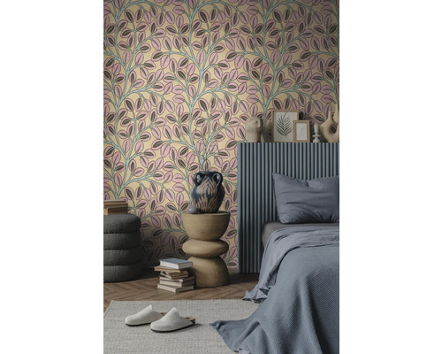 Vliestapete mit Blattmuster in Rosa und Grau in einem modern eingerichteten Schlafzimmer mit grauem Bett und Holzbeistelltisch.